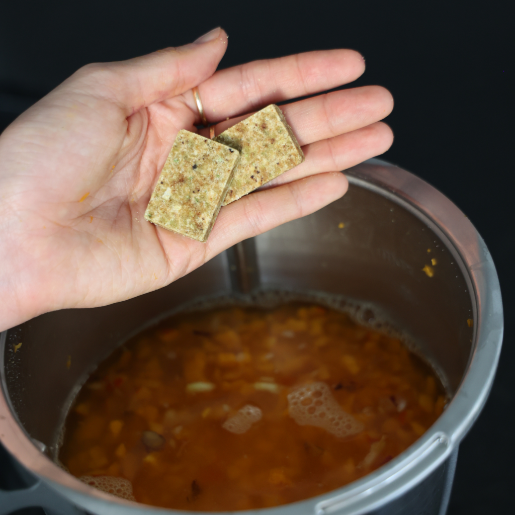 Suppenwürfel oder Gemüsebrühe für das Kürbisrisotto hinzufügen.