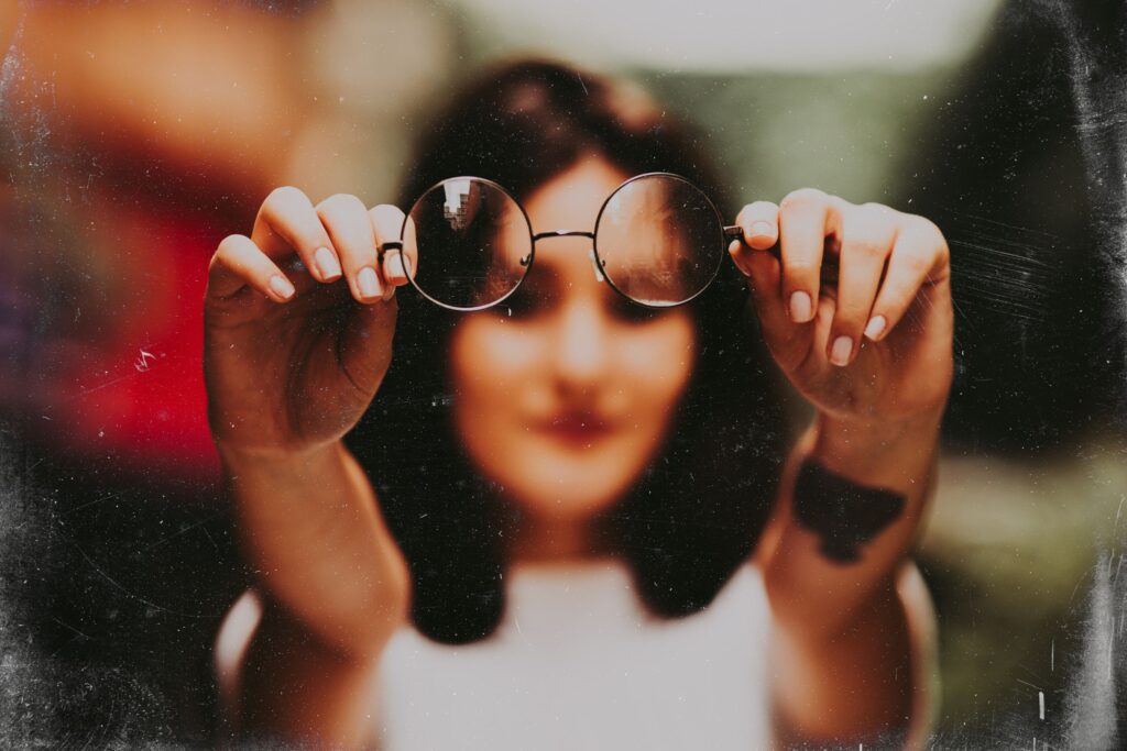 Frau hält eine Sehbrille in der Hand 