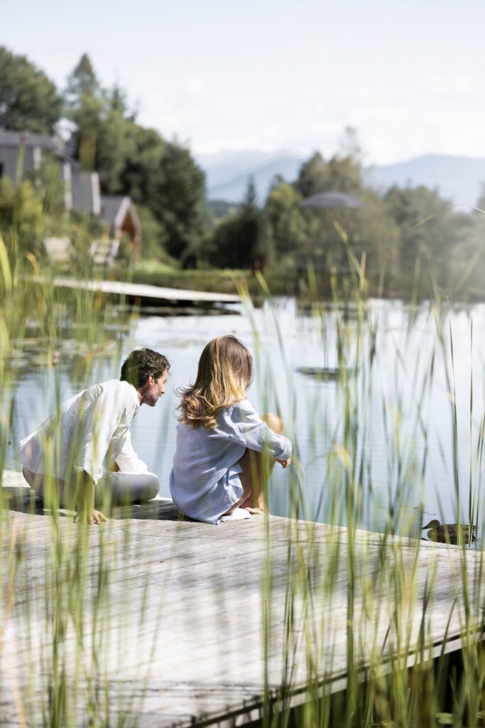 Pärchen sitzt am Teich in der Adler Lodge Ritten